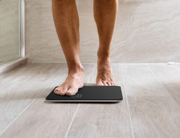 Barefooted Man Putting One Foot On The Bathroom Scales